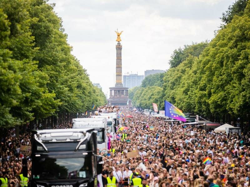 Der Zug des Christopher Street Day (CSD) zieht über die Straße des 17. Juni. Im Hintergrund: die Siegessäule. Foto: Christoph Soeder/dpa