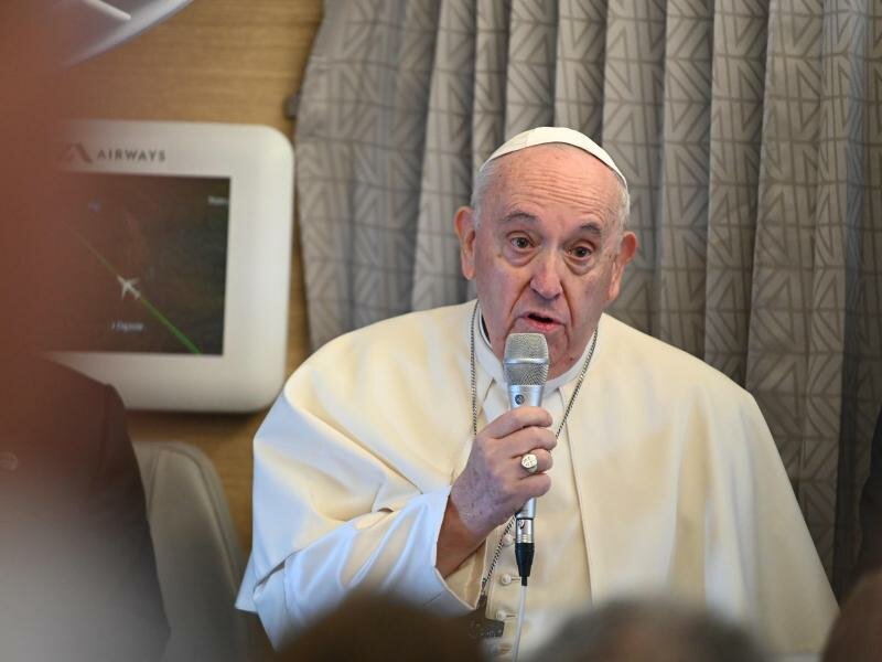 Papst Franziskus spricht vor Journalisten im Flugzeug. Der Papst bricht zu einer schwierigen Reise nach Kanada auf. Foto: Johannes Neudecker/dpa
