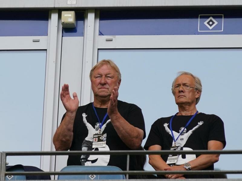Die beiden HSV-Legenden Horst Hrubesch (l) und Bernd Wehmeyer tragen Seeler auf der Burst. Foto: Marcus Brandt/dpa