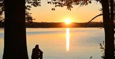 Ein Mann sitzt am Ufer des Starnberger Sees. Mit den eigenen Gedanken alleine zu sein finden viele Menschen angenehmer als vermutet. Foto: Katrin Requadt/dpa