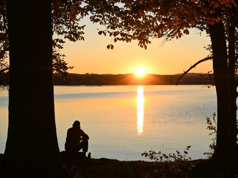 Ein Mann sitzt am Ufer des Starnberger Sees. Mit den eigenen Gedanken alleine zu sein finden viele Menschen angenehmer als vermutet. Foto: Katrin Requadt/dpa