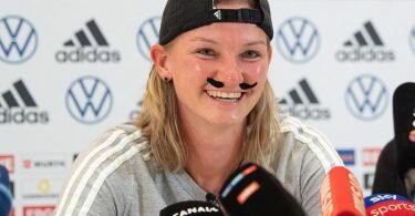 Alexandra Popp zeigte sich auf der Pressekonferenz mit einem Schnauzer. Foto: Sebastian Gollnow/dpa