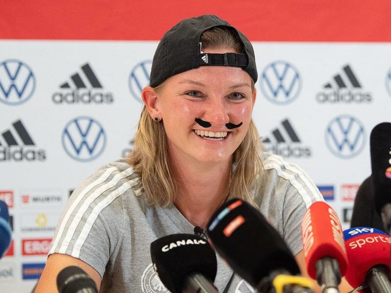 Alexandra Popp zeigte sich auf der Pressekonferenz mit einem Schnauzer. Foto: Sebastian Gollnow/dpa