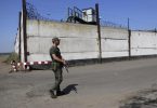Ein Soldat steht Wache neben der Mauer eines Gefängnisses in Oleniwka. Foto: -/AP/dpa