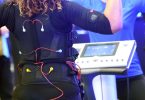 Bei einem EMS-Training trägt man eine verkabelte Weste und Manschetten, über die elektrische Impulse an den Körper weitergeleitet werden. Foto: Henning Kaiser/dpa-tmn