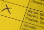 Ein Impfausweis mit bescheinigtem Masernschutz liegt auf einem Tisch. Foto: Marius Becker/dpa