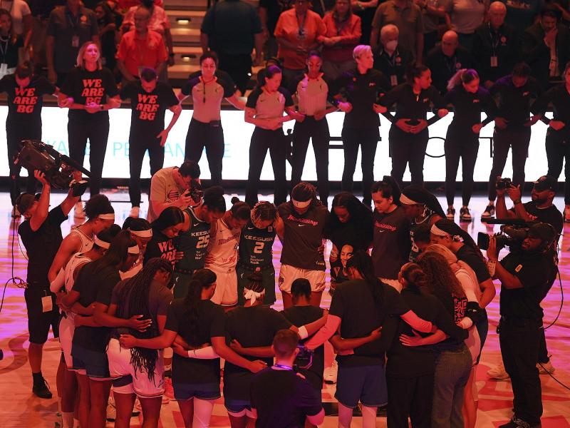 Die Teams der Connecticut Sun und der Phoenix Mercury verschränken vor einem Spiel der WNBA die Arme zu Ehren von Brittney Griner. Foto: Sarah Gordon/The Day/AP/dpa