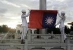 Zwei Soldaten falten die Nationalflagge während der täglichen Flaggenzeremonie auf dem Freiheitsplatz der Chiang-Kai-shek-Gedenkhalle in Taipeh. Foto: Chiang Ying-Ying/AP/dpa