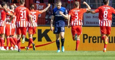 Die Mannschaft von Union jubelt nach dem 1:0 Treffer durch Sheraldo Becker - Herthas Jonjoe Kenny lässt den Kopf hängen. Foto: Andreas Gora/dpa