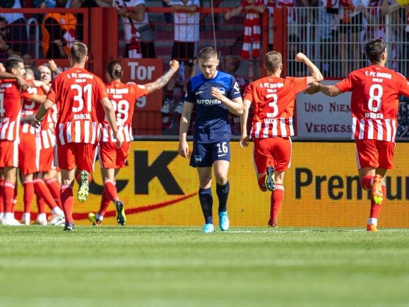 Die Mannschaft von Union jubelt nach dem 1:0 Treffer durch Sheraldo Becker - Herthas Jonjoe Kenny lässt den Kopf hängen. Foto: Andreas Gora/dpa