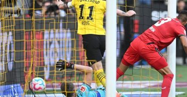 Dortmunds Marco Reus (M) stochert den Ball gegen Leverkusens Torwart Lukas Hradecky (l) und Piero Hincapie über die Linie. Foto: Bernd Thissen/dpa