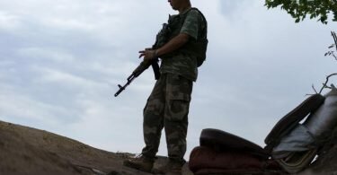 Ein ukrainischer Soldat hält in der Region Donezk Wache vor seinem Zelt. Foto: David Goldman/AP/dpa