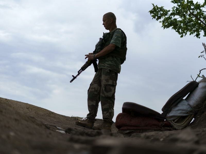 Ein ukrainischer Soldat hält in der Region Donezk Wache vor seinem Zelt. Foto: David Goldman/AP/dpa