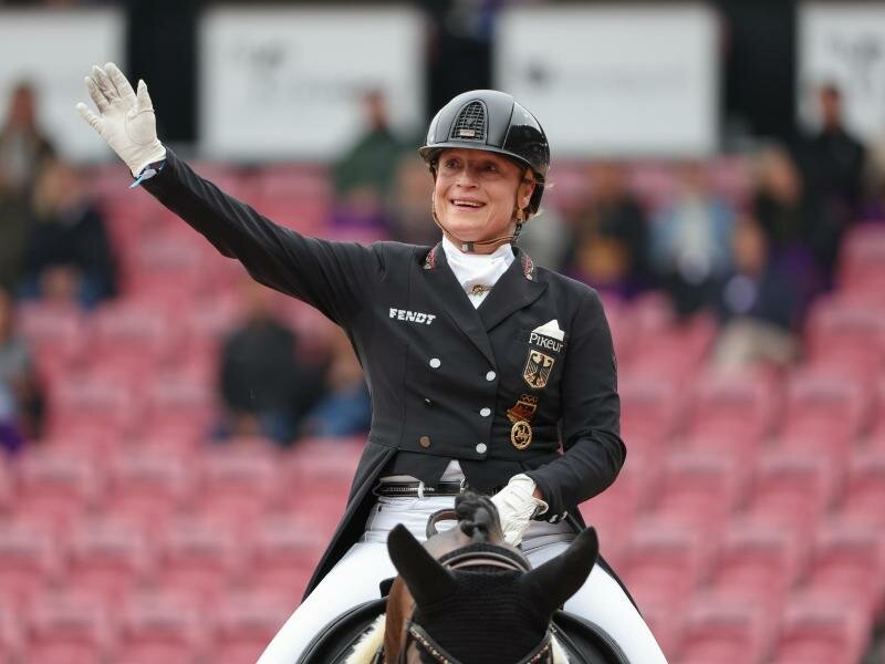 Dressurreiterin Isabell Werth winkt dem Publikum zu. Foto: Friso Gentsch/dpa