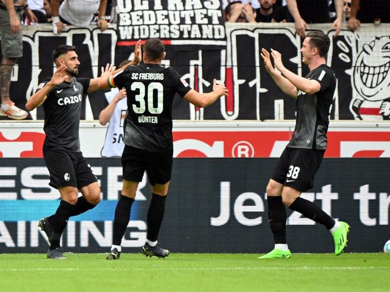 Torschütze Vincenzo Grifo, Christian Günter und Michael Gregoritsch (l-r) bejubeln den Treffer zum Freiburger 1:0. Foto: Uli Deck/dpa