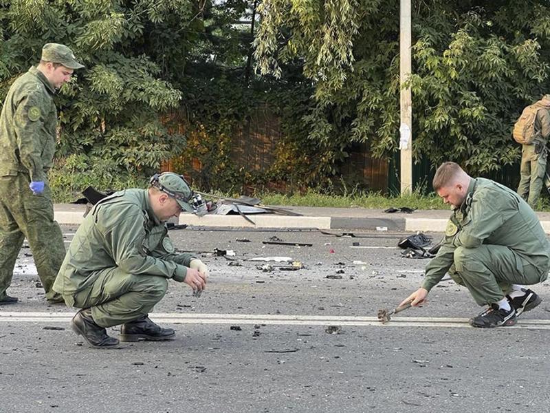 Ermittler am Ort der Explosion eines von Daria Dugina gefahrenen Autos außerhalb von Moskau. Foto: Uncredited/Investigative Committee of Russia/AP/dpa