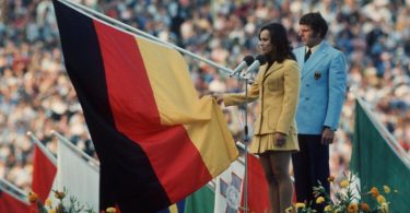 Fünfkämpferin Heidi Schüller spricht für die im Stadion versammelten Sportler den Olympischen Eid. Hinter ihr der Fahnenträger der deutschen Mannschaft Detlef Lewe. Foto: Hartmut Reeh/dpa