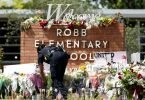 Eine Polizistin legt Blumen vor der Robb Elementary School in Uvalde nieder. Foto: Wu Xiaoling/XinHua/dpa
