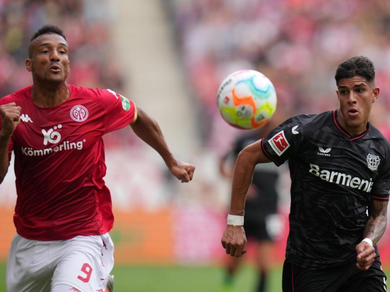 Der Mainzer Karim Onisiwo (l) und Leverkusens Panagiotis Retsos kämpfen um den Ball. Foto: Thomas Frey/dpa