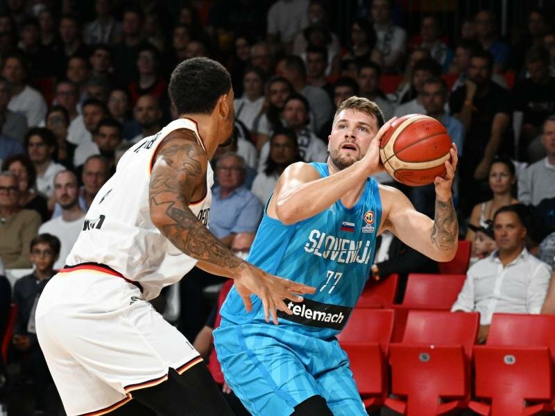 Dennis Schröder (l) in Aktion gegen Sloweniens Luka Doncic. Foto: Angelika Warmuth/dpa
