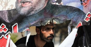 Ein Anhänger des schiitischen Geistlichen al-Sadr beobachtet den Rückzug der Demonstranten. Foto: Ameer Al-Mohammedawi/dpa