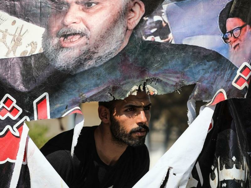 Ein Anhänger des schiitischen Geistlichen al-Sadr beobachtet den Rückzug der Demonstranten. Foto: Ameer Al-Mohammedawi/dpa