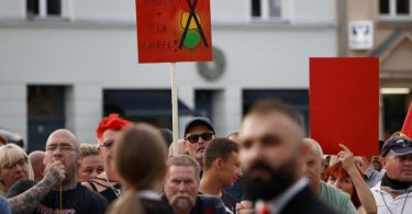 Zuschauer protestieren bei einer Veranstaltung mit Bundeskanzler Olaf Scholz in Neuruppin. Foto: Carsten Koall/dpa