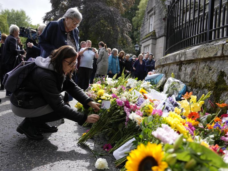 Menschen legen Blumen und letzte Grüße in der Nähe von Schloss Balmoral nieder. Doch nicht alle trauern um die Königin, zumal nicht in ehemaligen Kolonien. Foto: Alastair Grant/AP/dpa