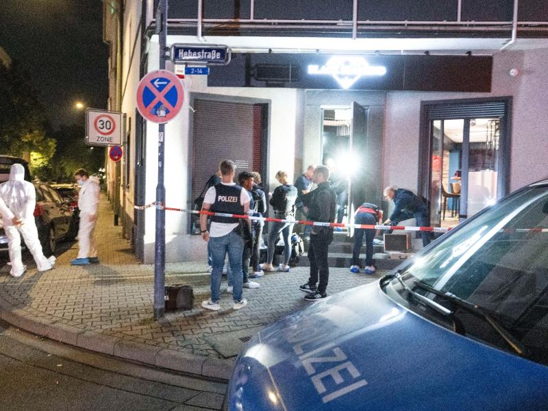 Polizisten sichern Spuren an einer Bar in Offenbach am Main. Foto: Boris Roessler/dpa