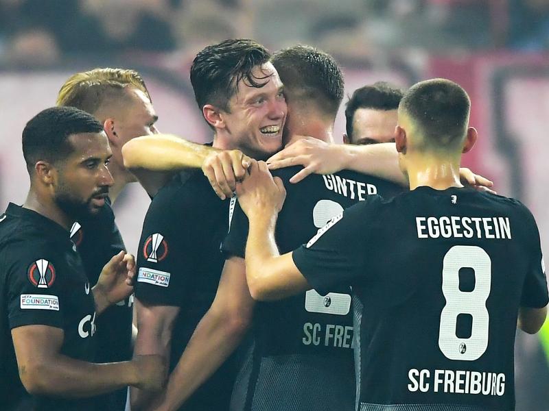 Die Spieler des SC Freiburg feiern den Sieg bei Olympiakos Piräus. Foto: Angelos Tzortzinis/dpa