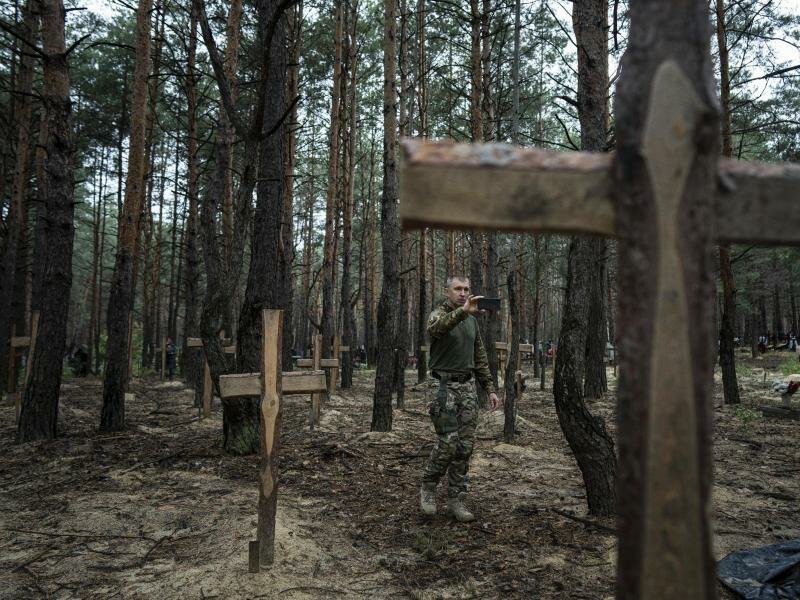 Ukrainischen Angaben zufolge wurden über 400 Leichen in einem Massengrab bei Isjum entdeckt. Foto: Evgeniy Maloletka/AP/dpa