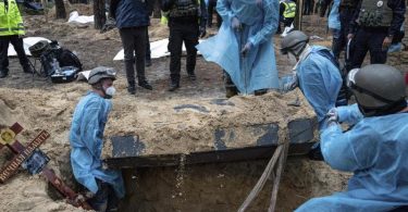 Ukrainische Rettungskräfte bergen bei der Exhumierung in Isjum einen Sarg. Foto: Evgeniy Maloletka/AP/dpa