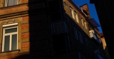 Die Sonne scheint zwischen zwei Häusern auf Fenster von Wohnungen. Foto: Sebastian Gollnow/dpa