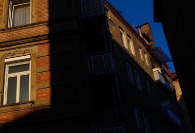 Die Sonne scheint zwischen zwei Häusern auf Fenster von Wohnungen. Foto: Sebastian Gollnow/dpa