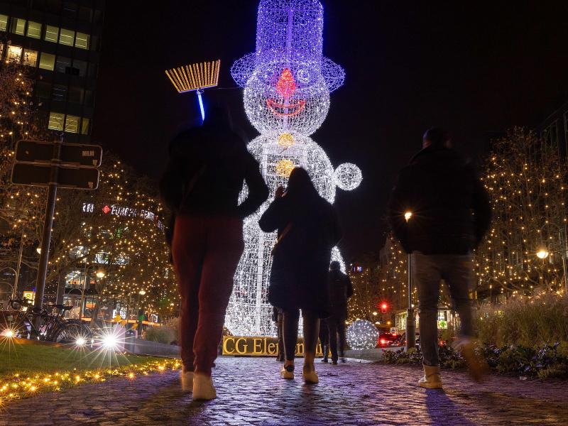 Dieses Jahr dunkel? Passanten gehen im November vergangenen Jahres an einer Schneemann-Illumination am Berliner Kudamm vorbei. Foto: Carsten Koall/dpa