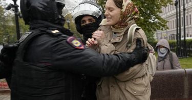 Bei einem Protest gegen die Teilmobilisierung in Moskau halten Polizisten eine Frau fest. Foto: Uncredited/AP/dpa