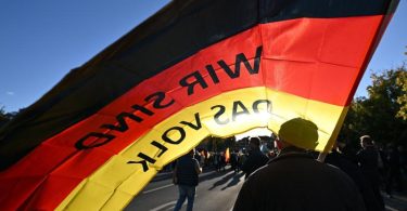 "Wir sind das Volk" steht auf einer Fahne, die ein Teilnehmer auf einer Kundgebung der Thüringer AfD im September trägt. Foto: Martin Schutt/dpa