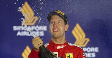 Ferrari-Pilot Sebastian Vettel lässt nach seinem Sieg 2019 in Singapur die Champagnerkorken knallen. Foto: Vincent Thian/AP/dpa/Archivbild